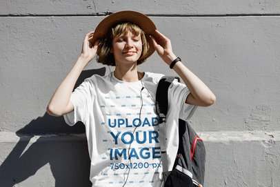 Mockup of a Happy Woman with a Unisex T-Shirt Leaning on a Wall 