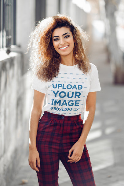 Mockup of a Smiling Young Woman Wearing a T-Shirt on the Street 
