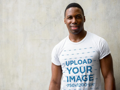 T-Shirt Mockup of a Smiling Man Standing Against a Wall
