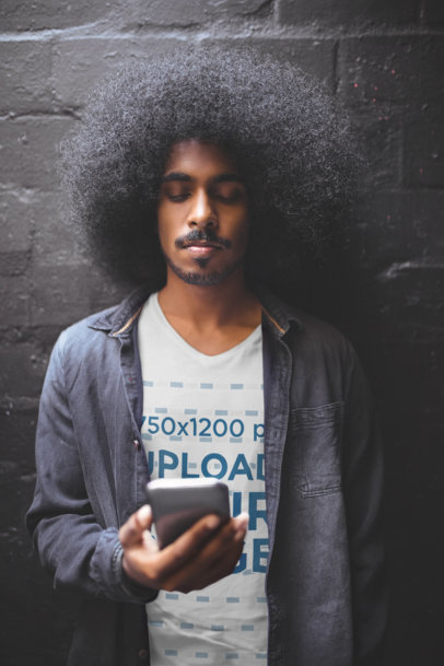 V-Neck T-Shirt Mockup of a Young Man Checking His Phone