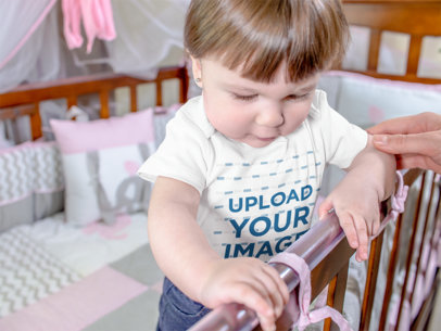 Beautiful Baby Girl Standing On Her Wooden Crib While Wearing A Onesie Mockup