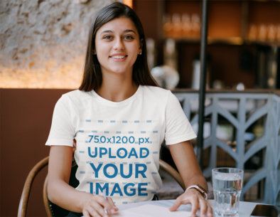 Mockup Featuring a Young Woman Wearing a T-Shirt at a Restaurant 