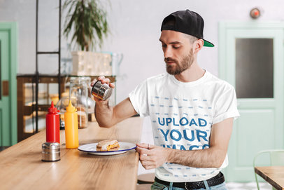 T-Shirt Mockup of a Bearded Man Pouring Some Salt on a Bagel
