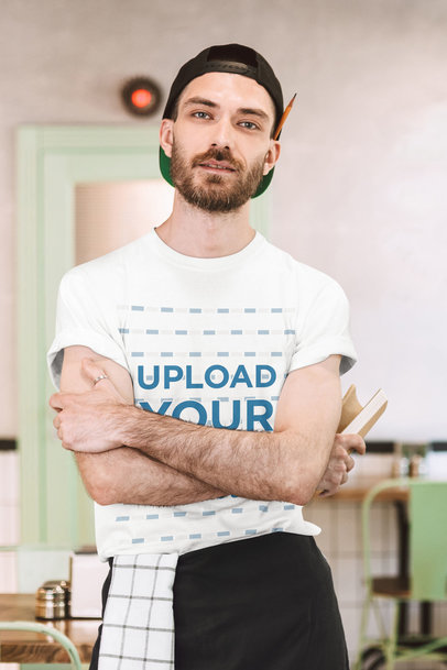 T-Shirt Mockup Featuring a Bearded Waiter Posing With His Arms Crossed 