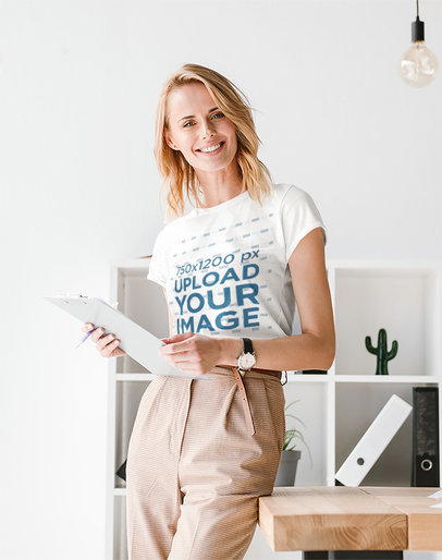 T-Shirt Mockup Featuring a Woman Posing at a Minimalist Office 