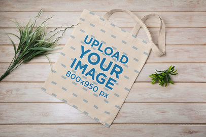 Mockup Featuring a Sublimated Tote Bag Placed on a Wooden Surface 