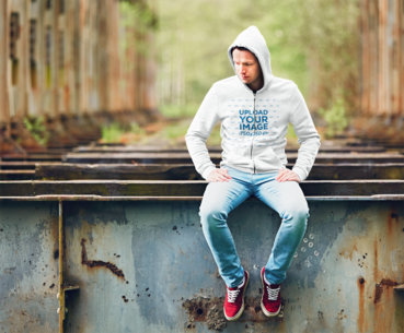 Hoodie Mockup of a Man Sitting on a Rusty Railroad