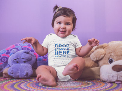Little Baby Girl Dancing And Wearing A Onesie While Sitting Down On Her Carpet With Teddies Mockup