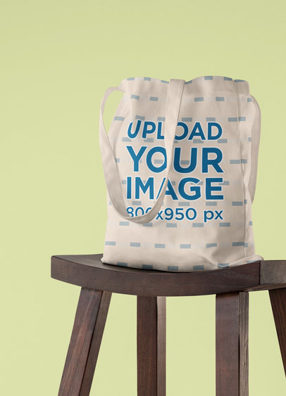 Mockup Featuring a Sublimated Tote Bag on a Wooden Stool 