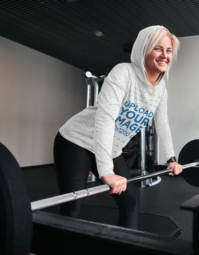 Heather Hoodie Mockup of a Fit Woman Lifting Weights at the Gym