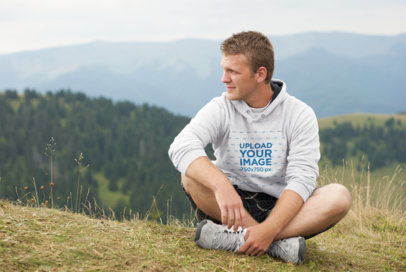 Mockup of a Man Wearing a Hoodie Featuring Mountains in the Background 40139-r-el2