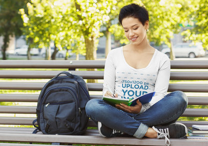 Mockup of a Woman with a V-Neck Long Sleeve Tee Sitting on a Park's Bench