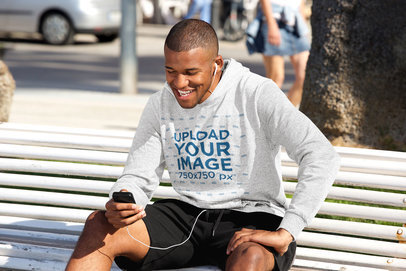 Mockup Featuring a Man with a Heathered Hoodie Checking His Phone