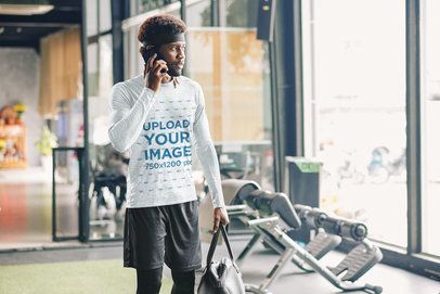 Heather Long-Sleeve Tee Mockup Featuring a Man Talking on the Phone at the Gym