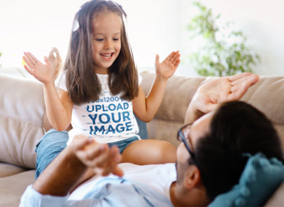 T-Shirt Mockup of a Girl Playing With Her Father on a Couch 