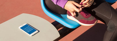 Mockup Of A White iPhone 6 Lying Over A Table While A Girl Is Tying Her Laces In A Plastic Chair a14094wide