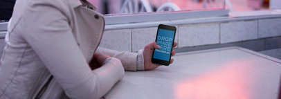 Mockup of a Woman with Sunglasses Holding Her iPhone 6