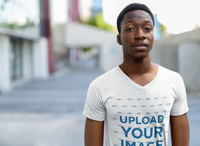 V-Neck T-Shirt Mockup Featuring a Serious Man in an Urban Setting