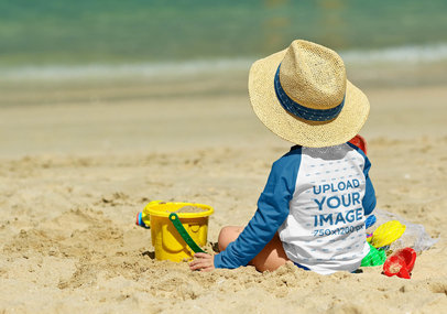 Back View Mockup of a Kid Wearing a Raglan Long-Sleeve Tee on the Beach