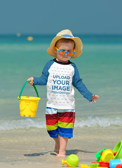 Mockup of a Baby Wearing a Raglan Long Sleeve Tee at the Beach 42127-r-el2