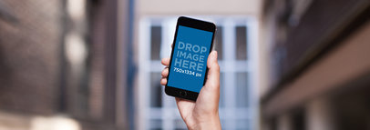 Mockup of an iPhone 6 Held High by a Man