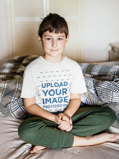 T-Shirt Mockup of a Boy Sitting on a Bed 