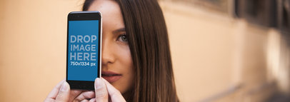 Mockup of a Woman Behind an iPhone in Portrait Position 