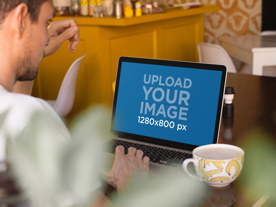 Mockup of a Bearded Man Working on a Macbook Pro at a Restaurant