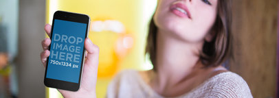 Mockup of a Short-Haired Woman Holding an iPhone