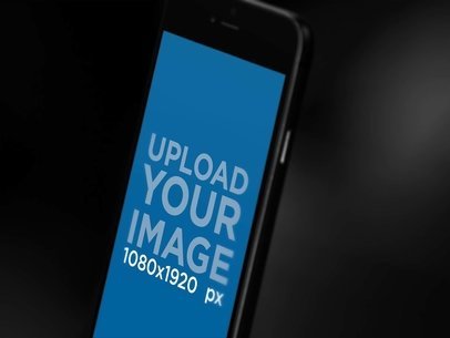 Angled Blurred Black iPhone 7 In Portrait Position Close Up Against Dark Background Mockup