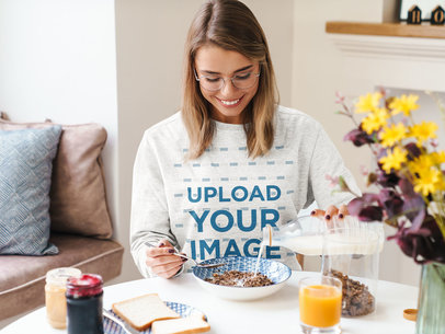 Mockup of a Woman with a Heathered Sweatshirt Having Cereal for Breakfast