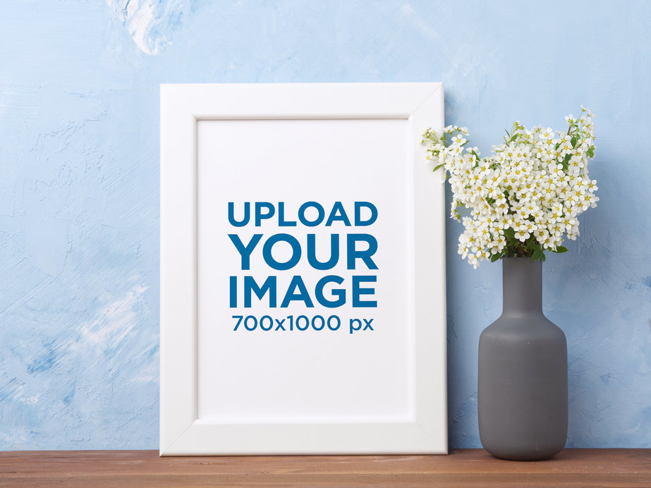Mockup of an Art Print Next to a Vase Filled with Flowers 