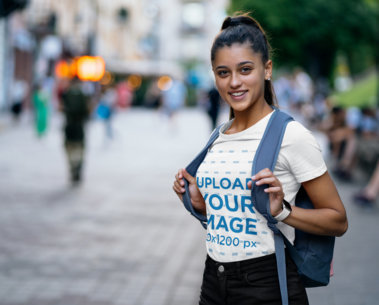 T-Shirt Mockup Featuring a Young Female Student on the Street
