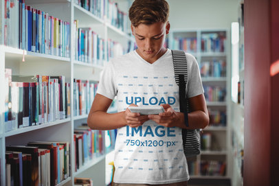 Mockup of a Teenager with a V-Neck Tee Standing in the Library