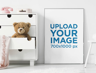 Mockup of an Art Print Placed by a Baby's Teddy Bear