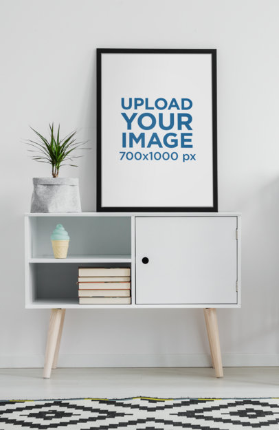 Mockup of an Art Print Placed on a Minimalist Furniture with a Plant