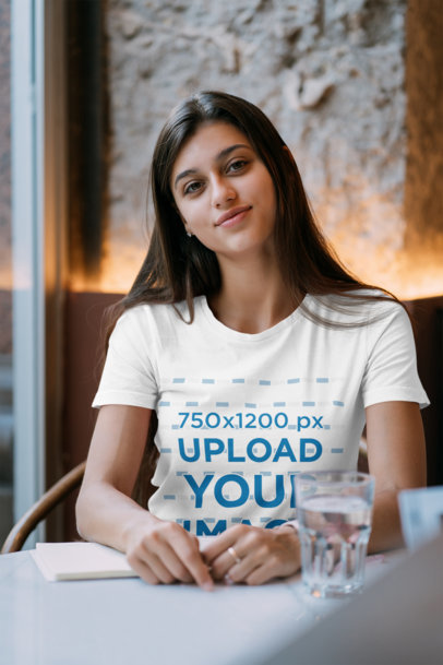 T-Shirt Mockup Featuring a Long-Haired Woman Studying at a Coffee Shop 