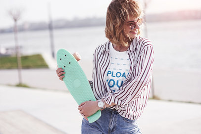 T-Shirt Mockup of a Happy Woman Holding a Penny Board in Her Hands