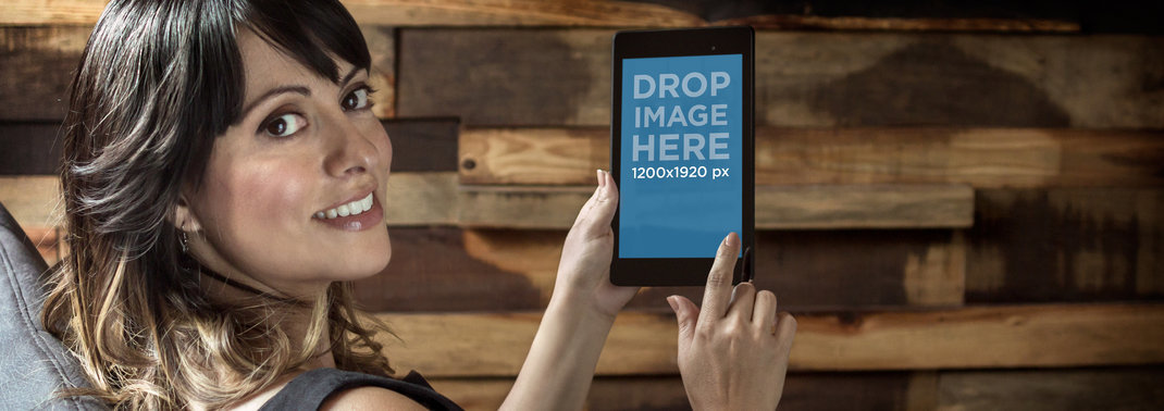 Wide Mockup Featuring a Smiling Woman Holding a Nexus 7 in Portrait Position