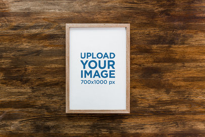 Mockup of a Framed Art Print Placed on a Wooden Surface