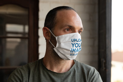 Mockup of a Serious Man With a Face Mask Posing by a Window 