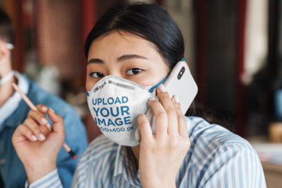 Mockup of a Woman on the Phone Wearing a Face Mask