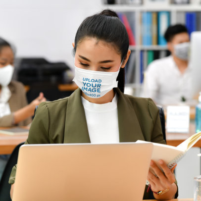 Face Mask Mockup of a Woman Working on Her Laptop at the Office