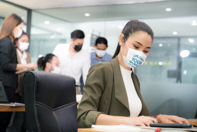 Face Mask Mockup Featuring a Woman Working in an Office