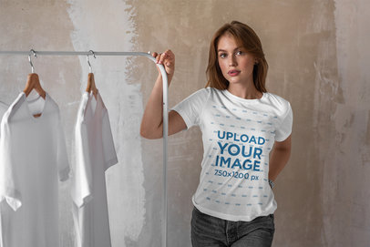 Tee Mockup of a Woman Standing Next to a Rack with T-Shirts