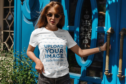 T-Shirt Mockup of a Woman Posing Outside a House with a Blue Door