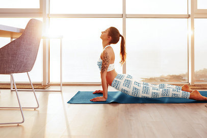 Sports Bra Mockup of a Woman Wearing Sublimated Leggings While Doing Yoga by a Window 