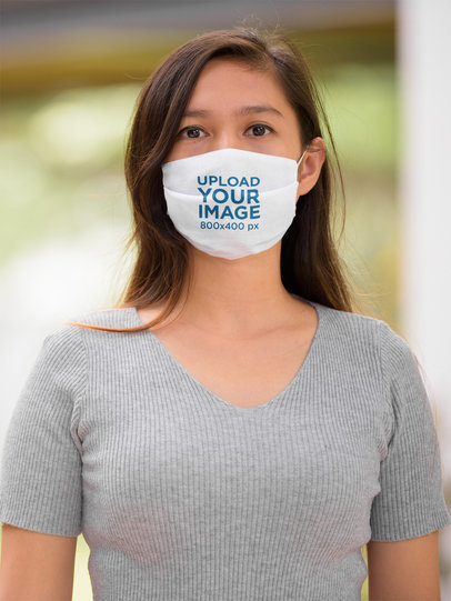 Mockup of a Serious Woman Wearing a Customizable Face Mask 