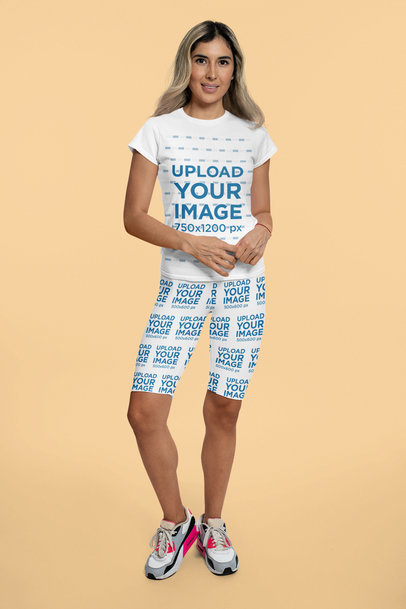 Mockup of a Woman Posing with a T-Shirt and Bike Shorts in a Studio