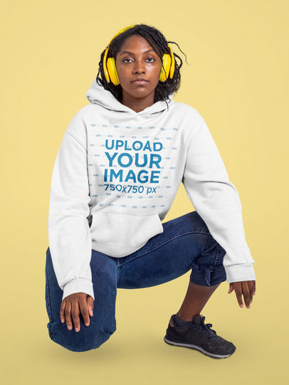 Hoodie Mockup of a Woman with Headphones Posing Against a Customizable Background 